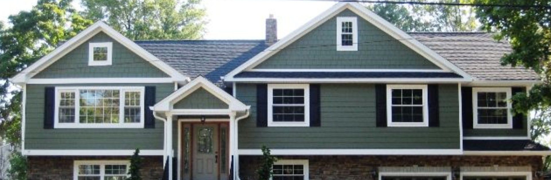 A house with green siding and white trim.