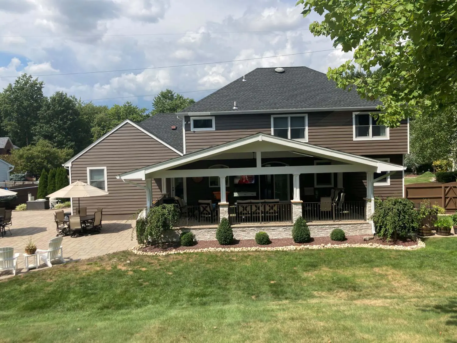 A large house with a patio and lawn area.